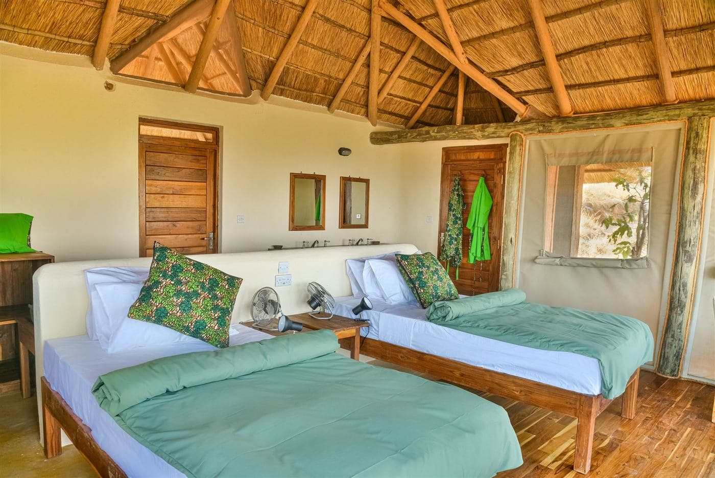 Twin beds in a thatched bush bedroom