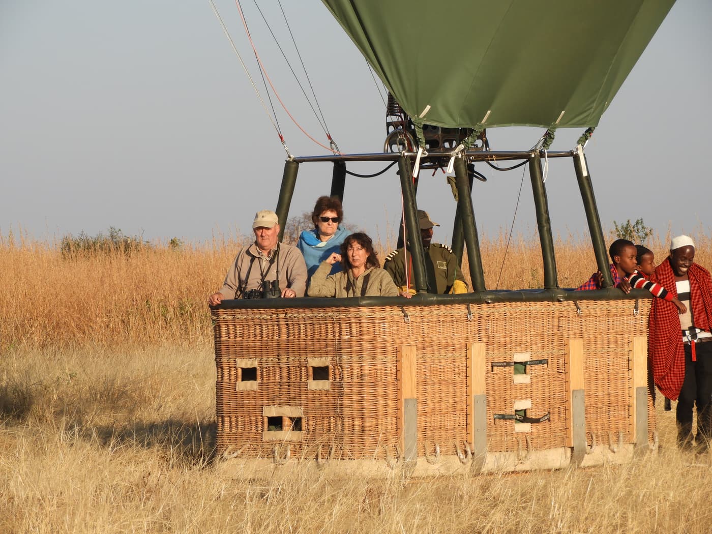 Guests in the basket of a hot air balloon at dawn